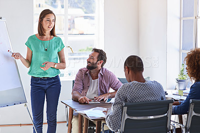 Buy stock photo Shot of a young businesswoman giving a presentation to her design team