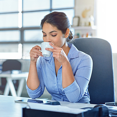 Buy stock photo Shot of a young businesswoman drinking a beverage at work