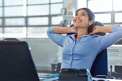 Buy stock photo Shot of a young businesswoman relaxing at her work desk