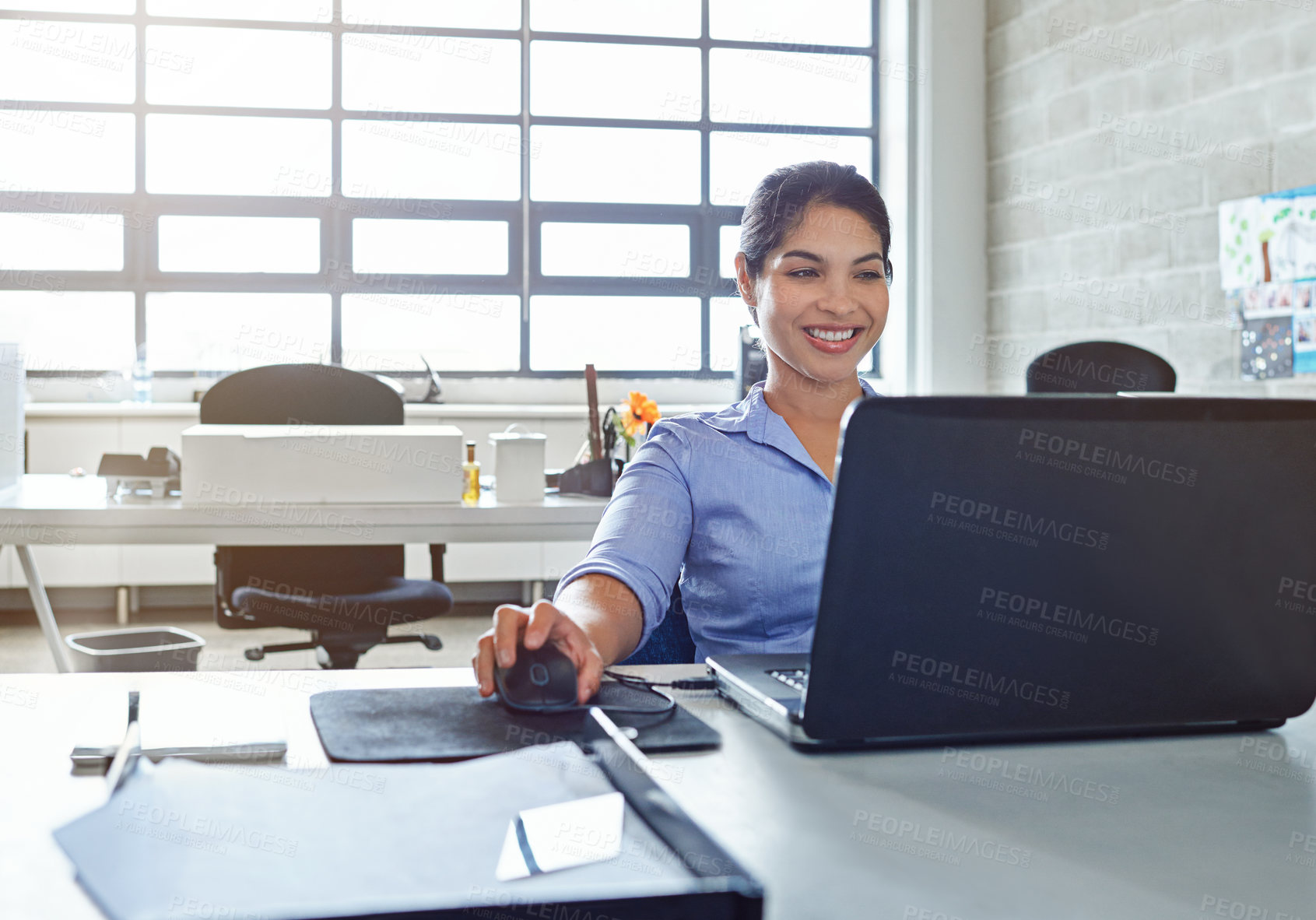 Buy stock photo Shot of a young businesswoman using a laptop at work