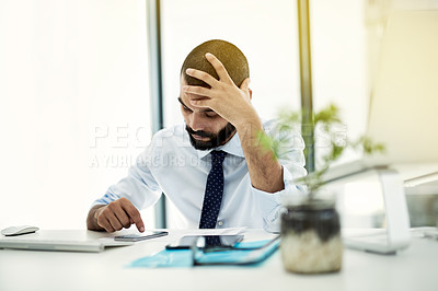 Buy stock photo Shot of a young businessman hard at work at his desk in an office