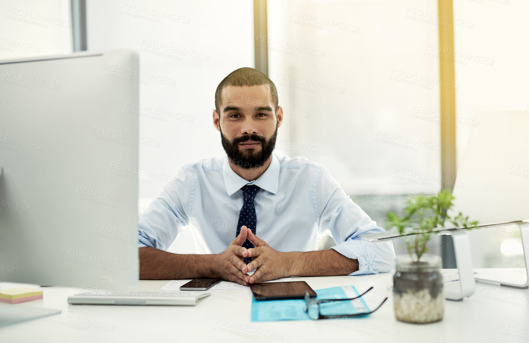 Buy stock photo Portrait of a young businessman working at his desk in an office