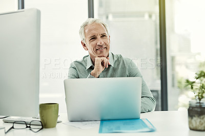 Buy stock photo Portrait of a mature businessman working on a computer at his desk in an office