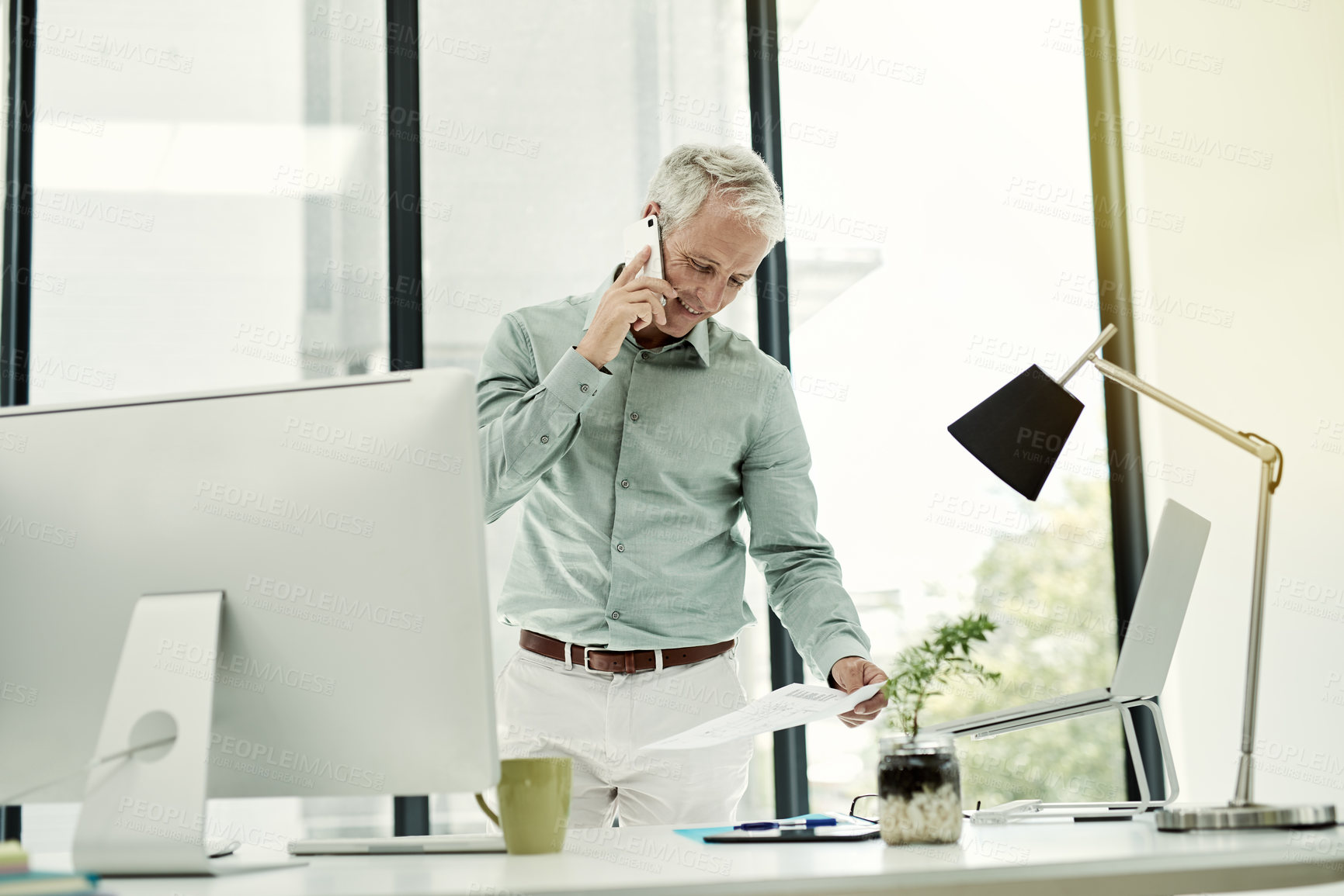 Buy stock photo Happy, businessman and document on phone call at office for communication or networking as financial analyst. Mature person, employee and smile on conversation, consultation and connection for advice