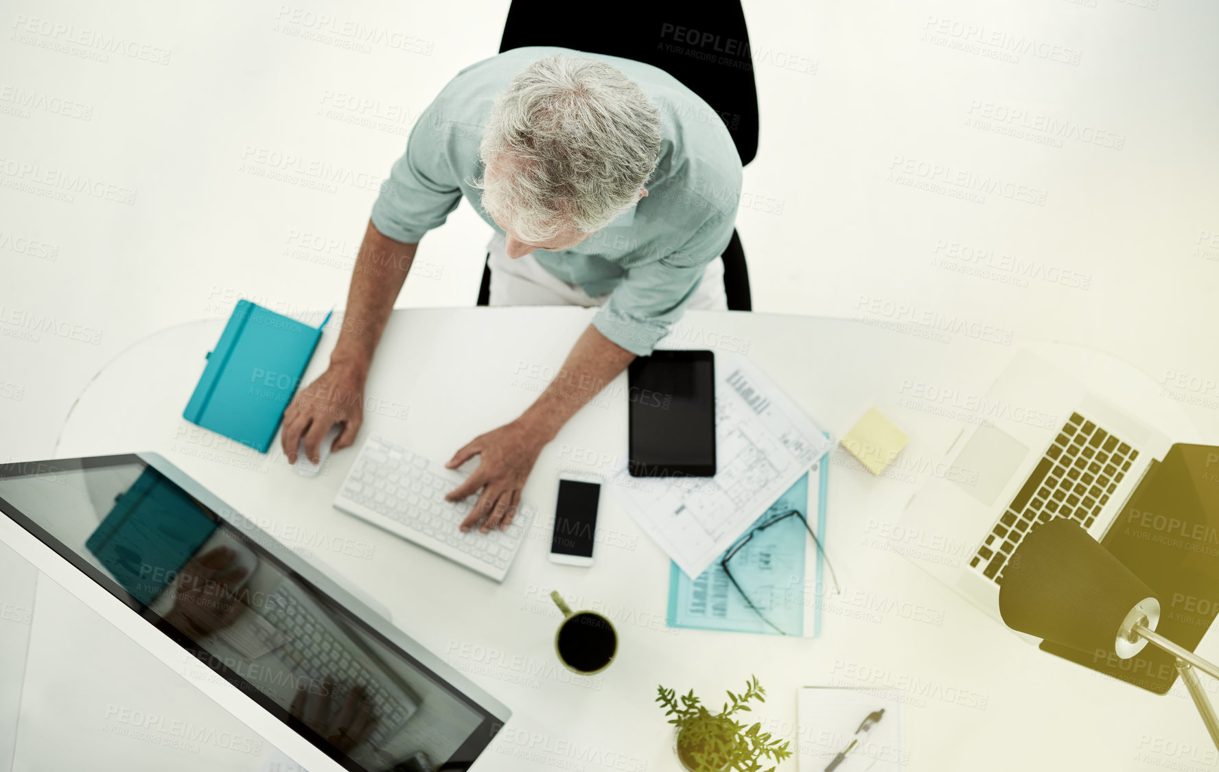 Buy stock photo High angle shot of a mature businessman working on a computer  at his desk in an office