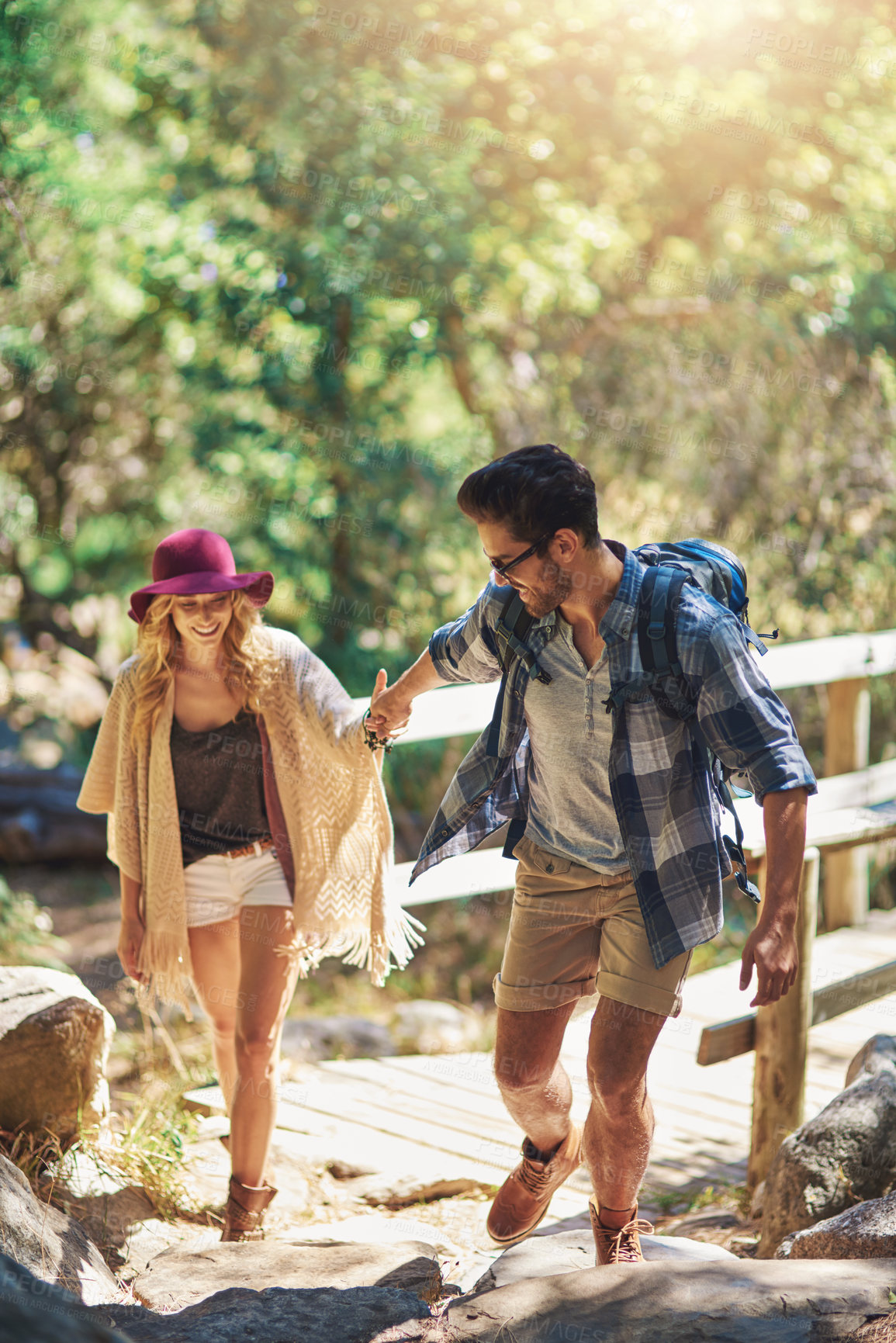 Buy stock photo Couple, walking and bridge in nature for hiking outdoor on vacation, together and hand holding in forest for adventure. Man, woman and woods for explore on travel holiday in New Zealand with love.