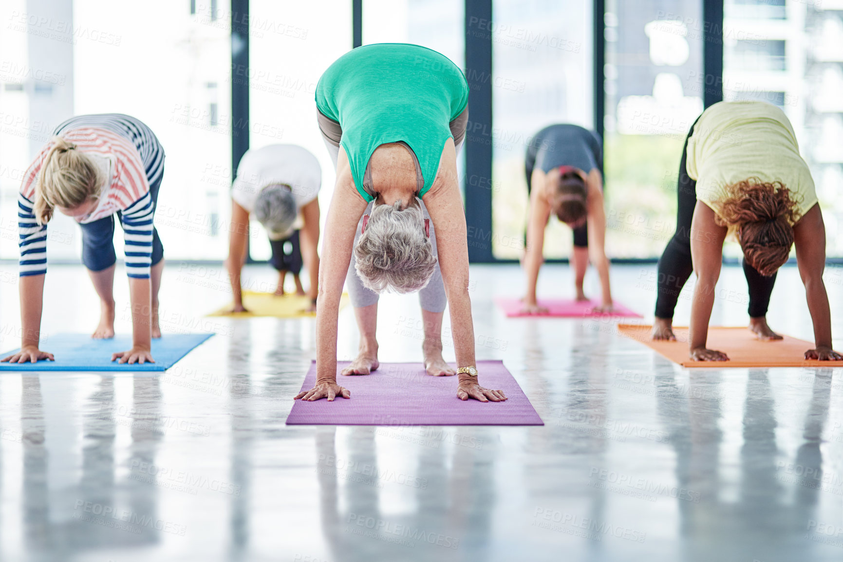 Buy stock photo Shot of a group of women doing yoga indoors