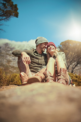 Buy stock photo Shot of an affectionate young couple taking a break while hiking