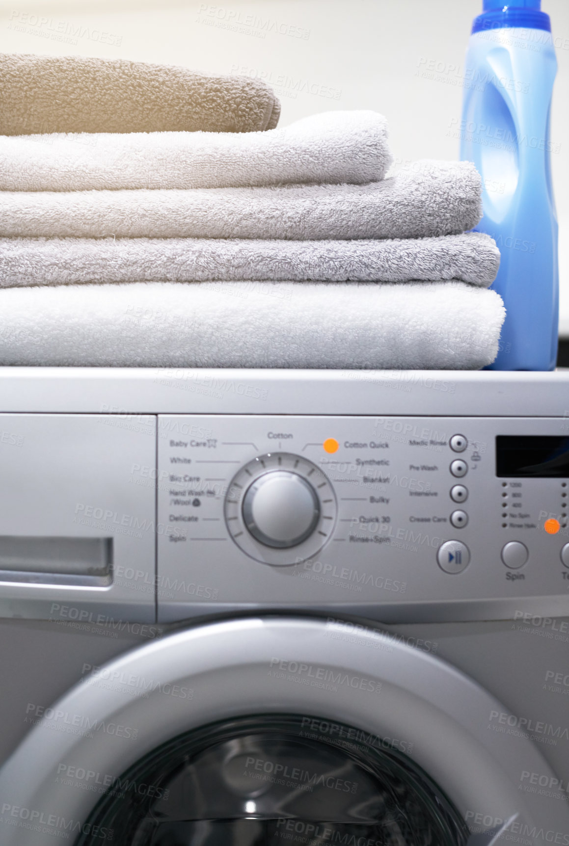 Buy stock photo Shot of a washing machine with folded towels and detergent on top of it