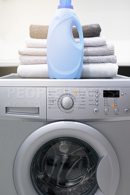 Buy stock photo Shot of a washing machine with folded towels and detergent on top of it