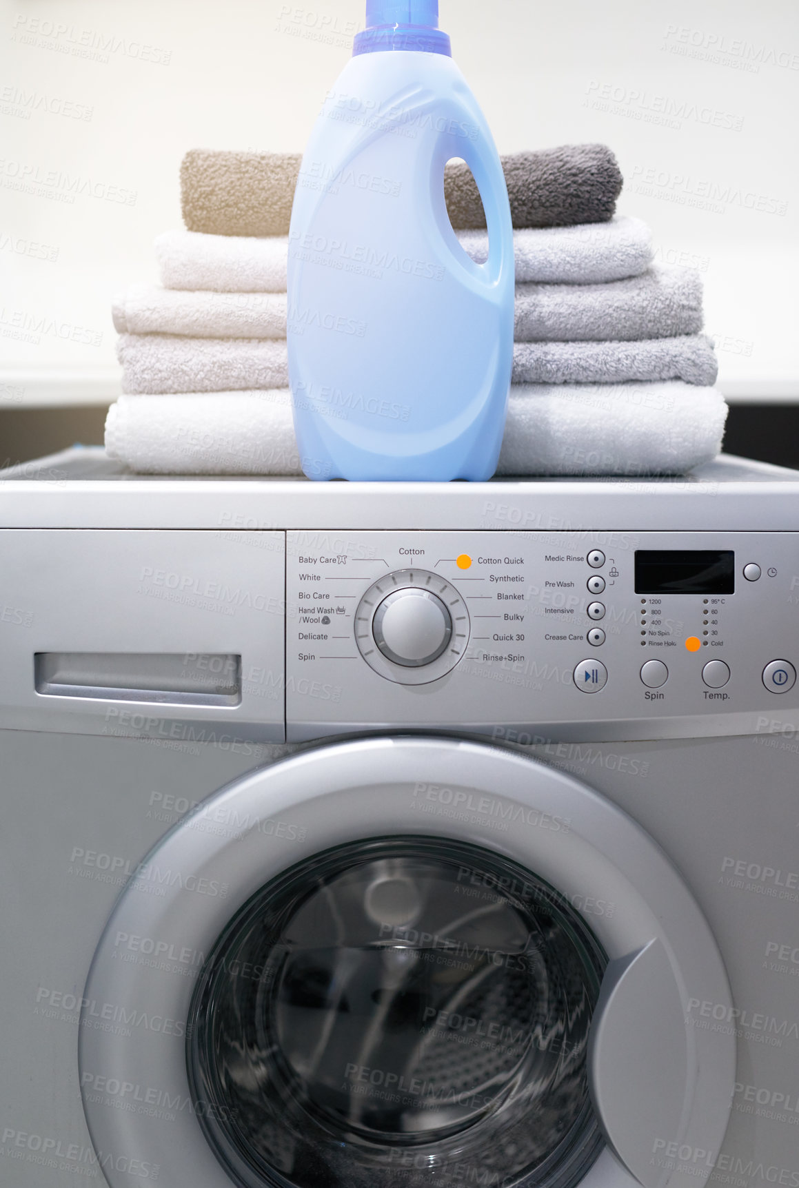 Buy stock photo Shot of a washing machine with folded towels and detergent on top of it