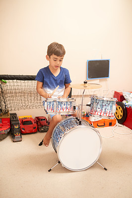 Buy stock photo Young boy, drum kit and learning in bedroom for talent, music and creative development in apartment. Child, learning and practice in house for skill, enjoyment and instrument in home for training