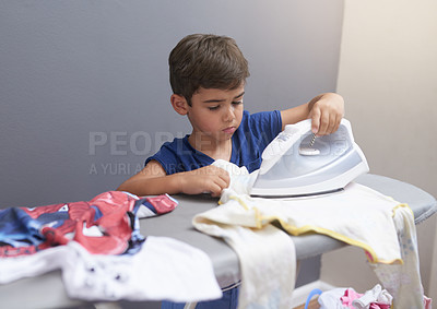 Buy stock photo Child, boy and ironing in home with housework for cleaning, sad and punishment with routine or danger. Kid, clothes and housekeeping for responsibility, learning or chores with independence in lounge