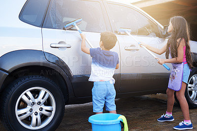 Buy stock photo Shot of a little boy and his sister washing a car at home