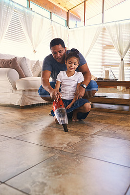 Buy stock photo Shot of a father and daughter vacuuming the floor