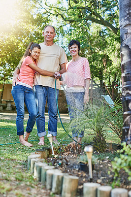 Buy stock photo Portrait of a family watering a garden with a hose