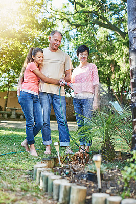 Buy stock photo Family, bonding and watering plants in backyard garden for sustainability, environmental or agriculture. Landscaping, mature parents and young girl in nature for growth, learning or development