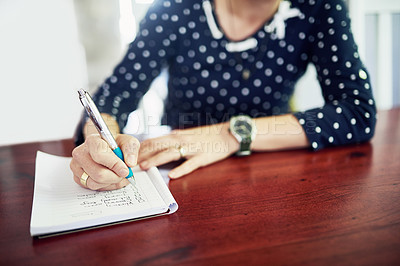 Buy stock photo Woman writing a to do list in a note book or diary. Closeup of hand holding a pen to plan, manage and organise schedule with a checklist of tasks and reminders. Marking household chores on paper