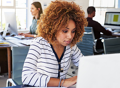 Buy stock photo Black woman serious in startup and typing on laptop in modern office as copywriter or journalist, creative and content research. Wifi, busy female and productivity with copywriting at media company
