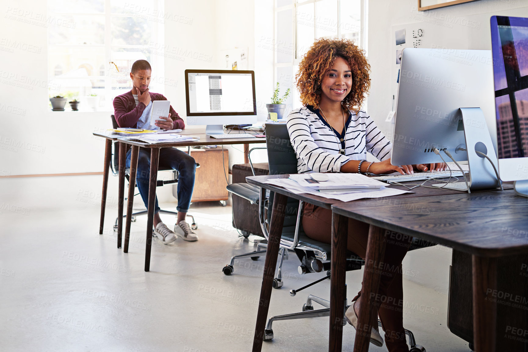 Buy stock photo Portrait of a young woman working on her computer in an open plan office