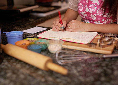 Buy stock photo Shot of a woman writing in a recipe book