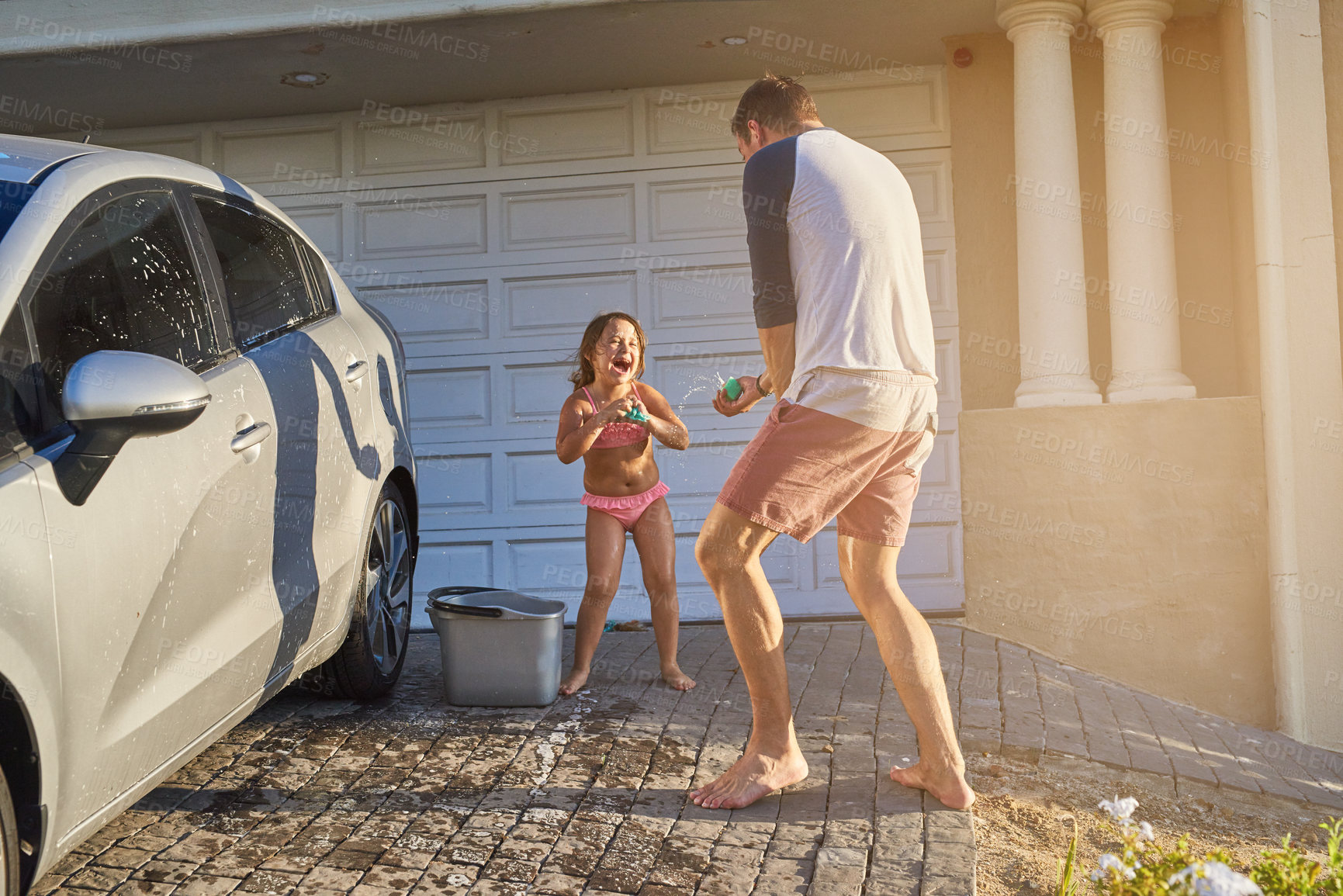 Buy stock photo Shot of a father and daughter having fun while washing a car
