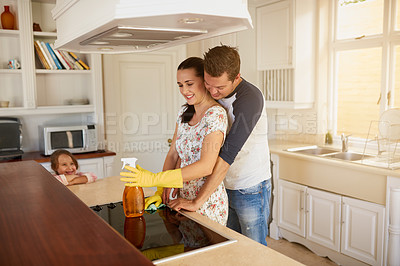 Buy stock photo Family, spray bottle and hug in kitchen for happiness, bond and marriage in apartment. Mom, dad and spring cleaning in house for disinfecting, maintenance and hygiene in home with child and love