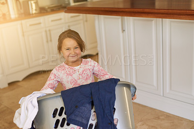 Buy stock photo Smile, basket and child with laundry in home for learning to clean with development and growth. Happy, kitchen and portrait of girl kid with clothes for washing with housekeeping at apartment.