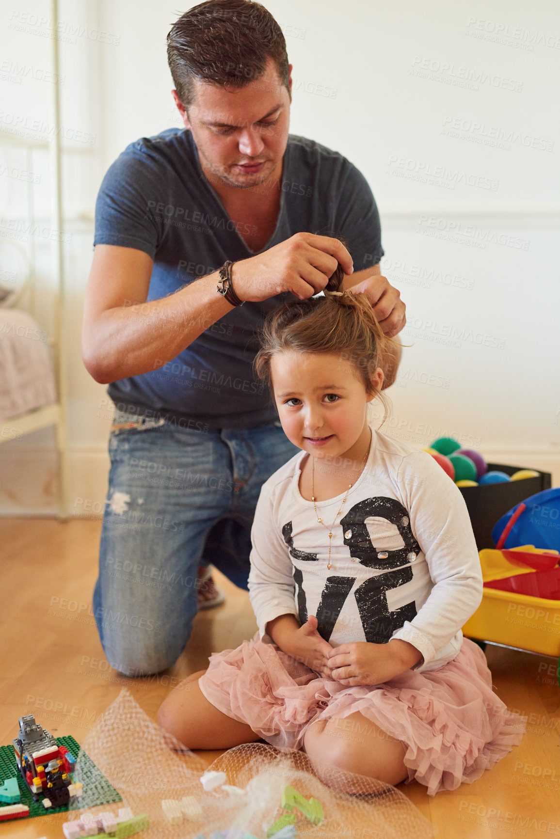 Buy stock photo Shot of a father styling his daughter's hair at home