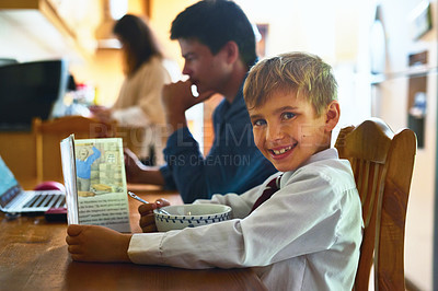 Buy stock photo Portrait of a young boy sitting at the breakfast table with his parents in the background