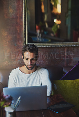 Buy stock photo Cropped shot of a young man using his laptop in a coffee shop