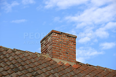 Buy stock photo Red brick chimney designed on slate roof of a house building outside with blue sky background and copyspace. Exterior construction architecture of escape chute on rooftop for fireplace smoke and heat