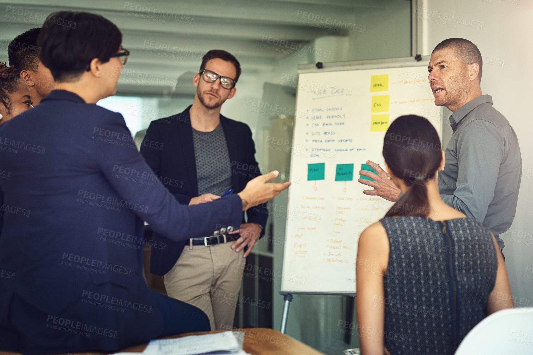 Buy stock photo Shot of a group of colleagues having a meeting together around a whiteboard in an office