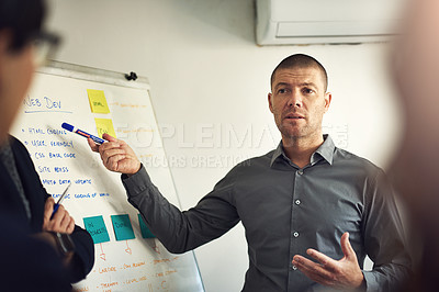 Buy stock photo Shot of a man giving a presentation to colleagues in an office