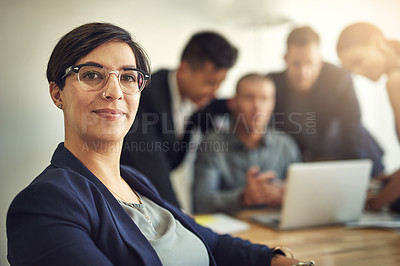 Buy stock photo Portrait of a businesswoman with her colleagues blurred in the background