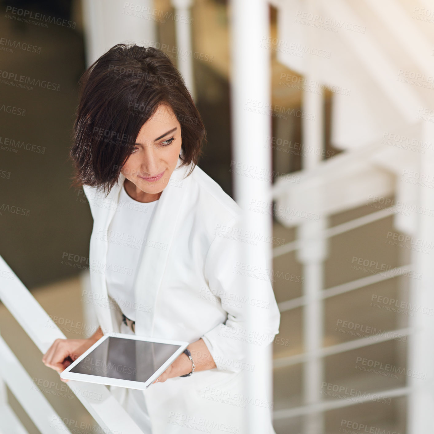 Buy stock photo Shot of a young businesswoman standing with a digital tablet in an office