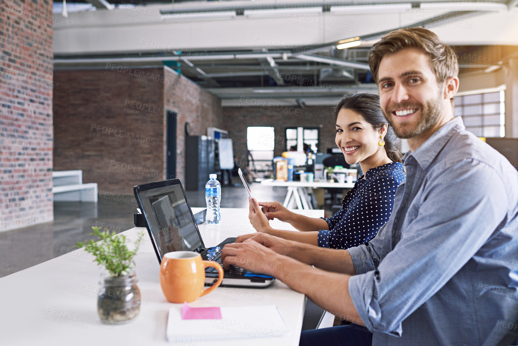 Buy stock photo Teamwork, office and portrait of man and woman at desk with laptop at creative agency, working on project together. Leadership, partnership and happy employees or business partner at design startup.
