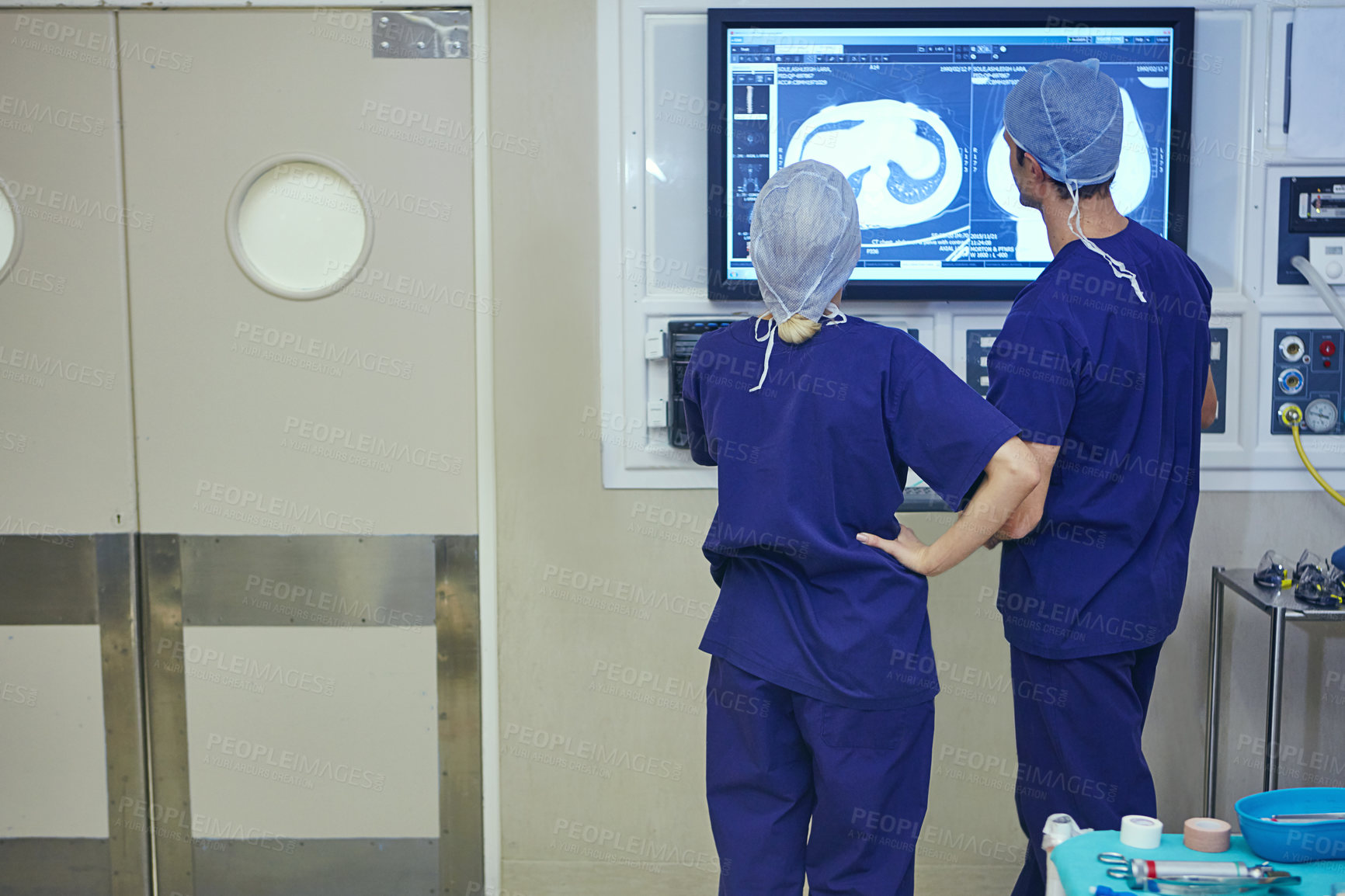 Buy stock photo Shot of a team of surgeons discussing a patient’s medical scans