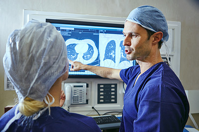 Buy stock photo Shot of a team of surgeons discussing a patient’s medical scans