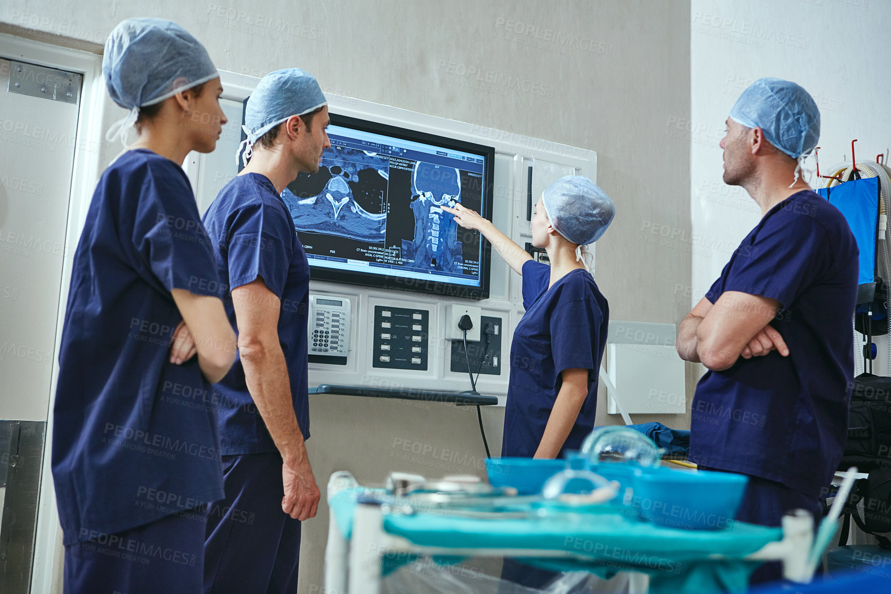 Buy stock photo Shot of a team of surgeons discussing a patient’s medical scans