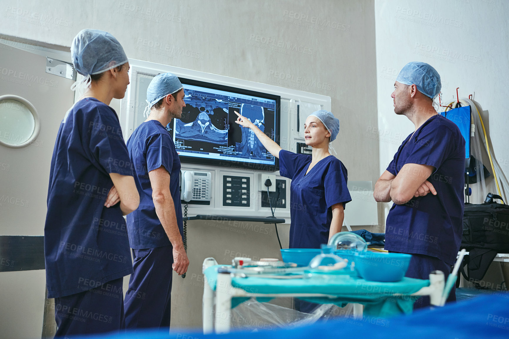 Buy stock photo Shot of a team of surgeons discussing a patient’s medical scans