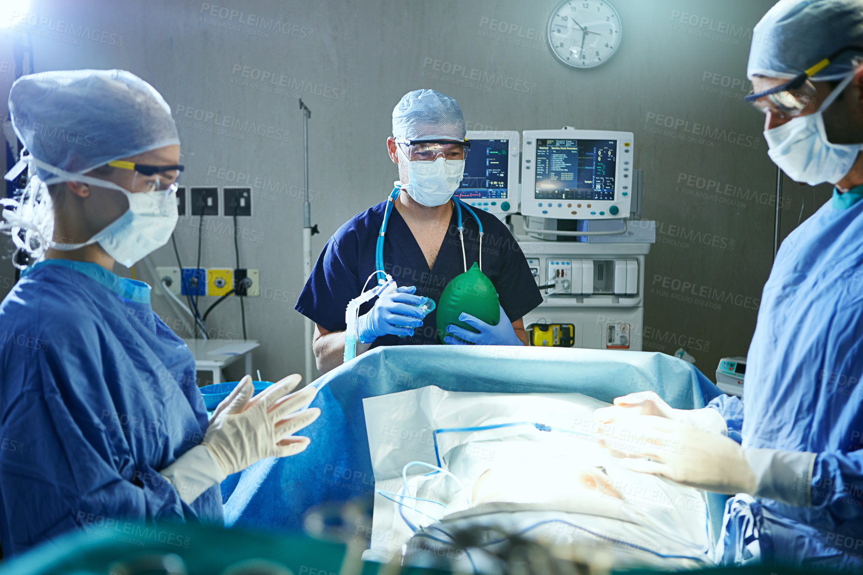 Buy stock photo Surgeon, teamwork and people in operating room, healthcare and clinical support with lights. Cooperation, professional or employees in hospital, medical emergency service and procedure with face mask