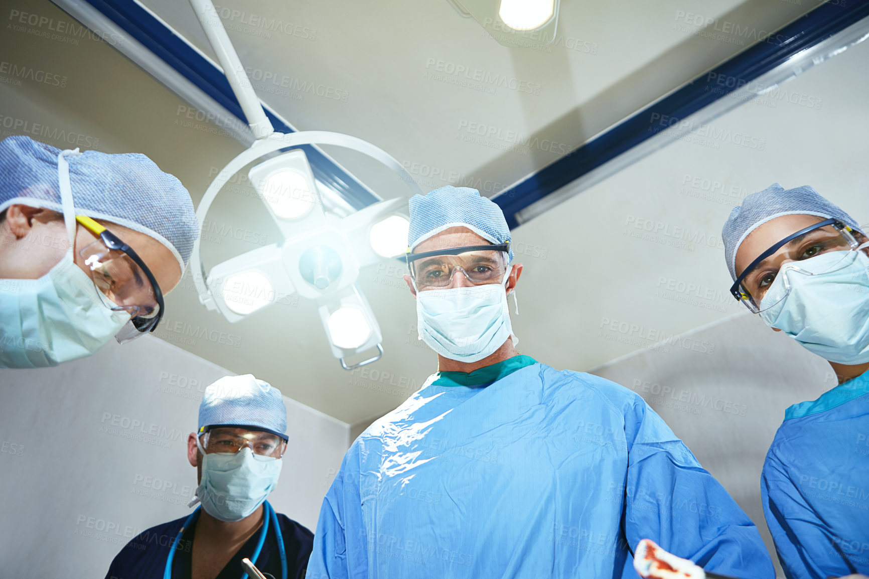 Buy stock photo Low angle shot of surgeons in an operating room