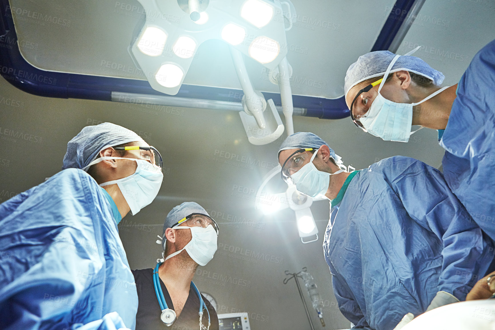 Buy stock photo Low angle shot of surgeons in an operating room