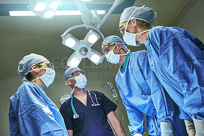 Buy stock photo Low angle shot of surgeons in an operating room