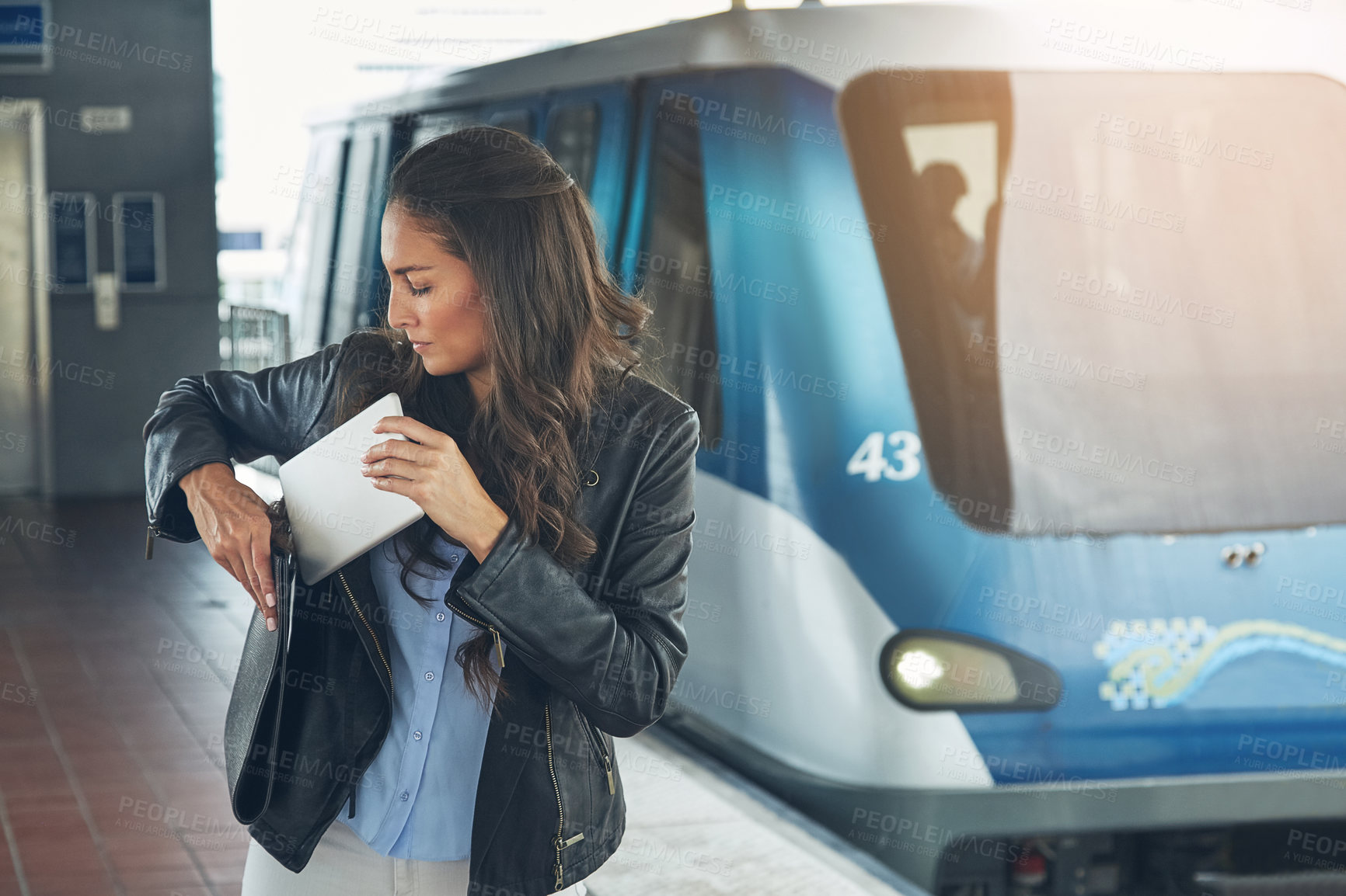 Buy stock photo Shot of a young woman using a digital tablet at a train station