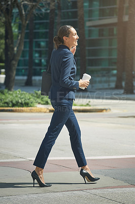 Buy stock photo Shot of a young businesswoman talking on her phone while out in the city