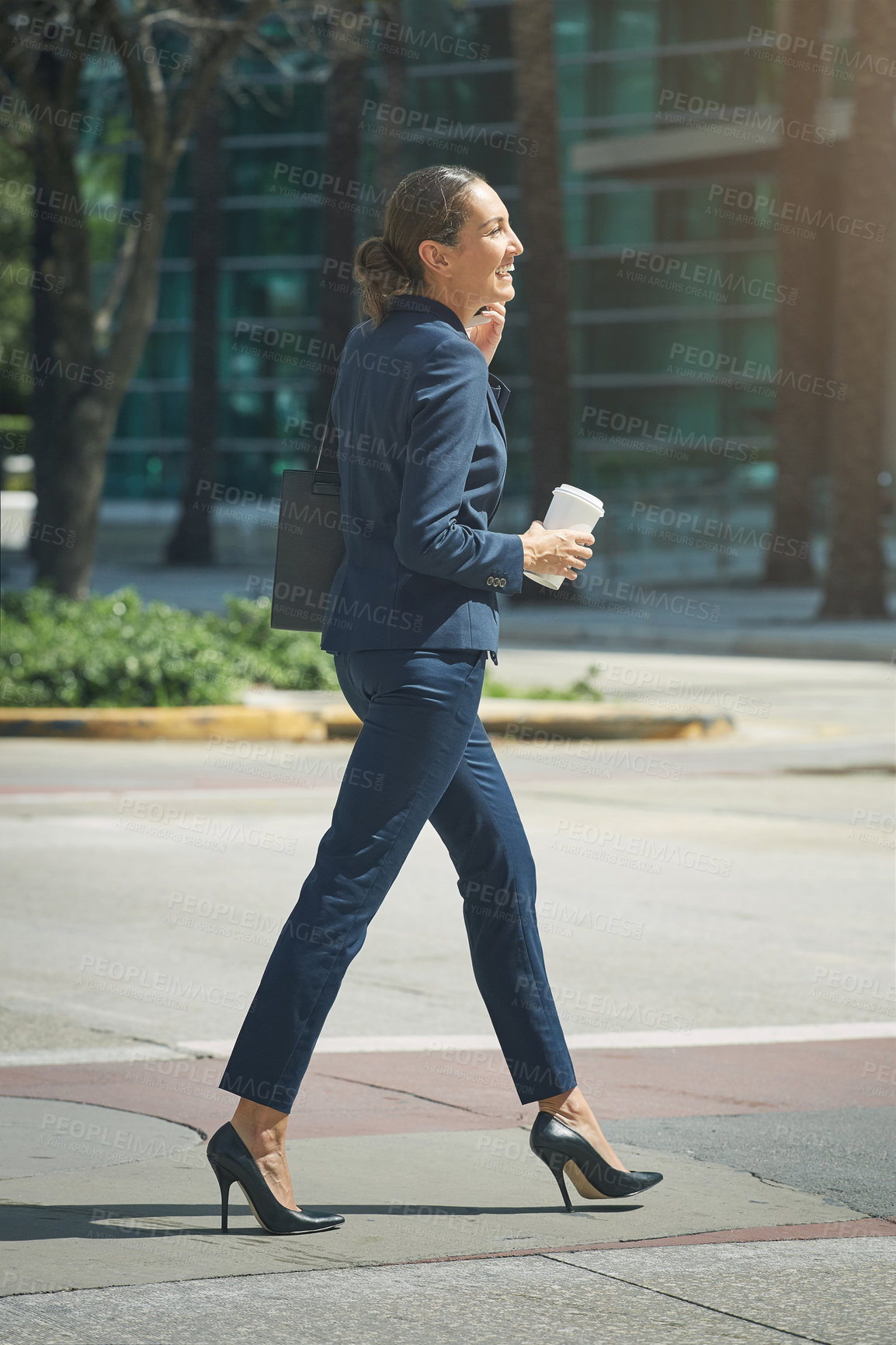 Buy stock photo Shot of a young businesswoman talking on her phone while out in the city