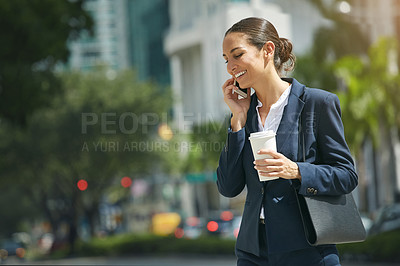 Buy stock photo Shot of a young businesswoman talking on her phone while out in the city