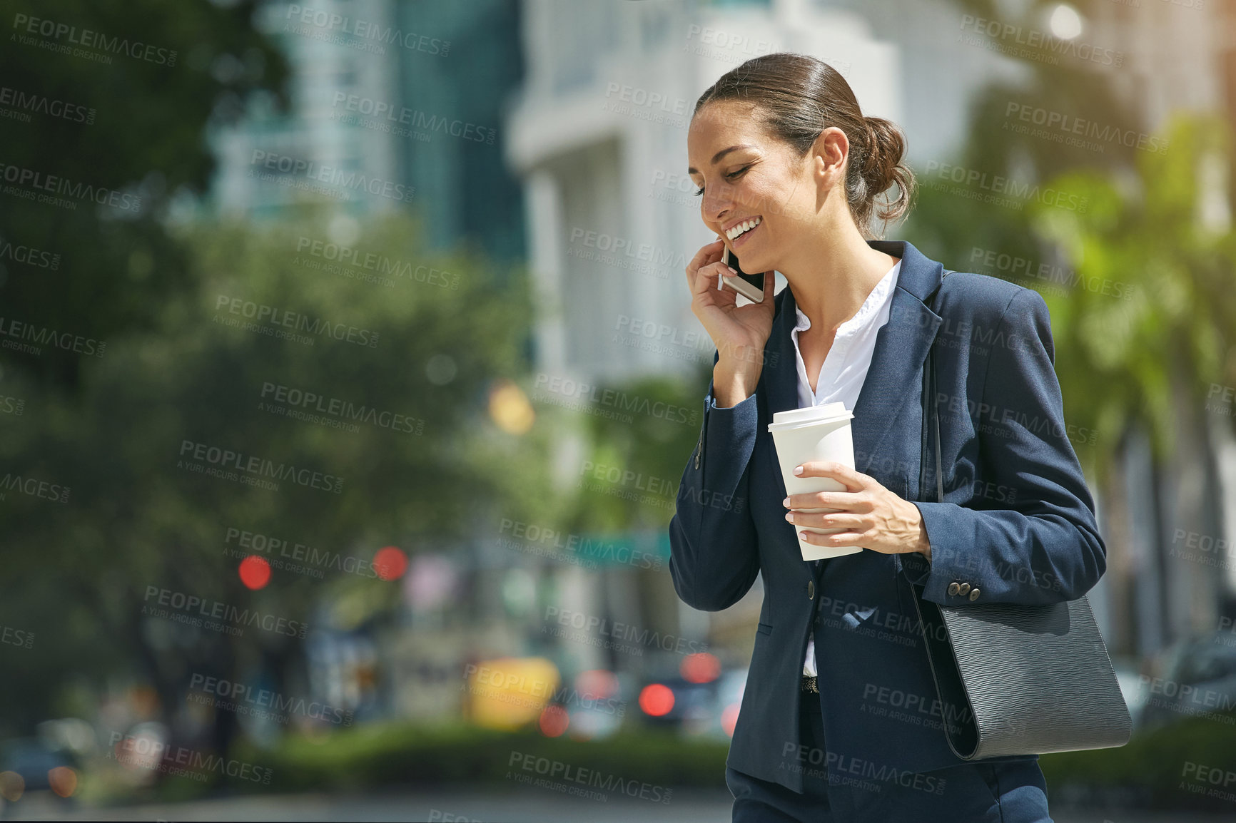 Buy stock photo Shot of a young businesswoman talking on her phone while out in the city